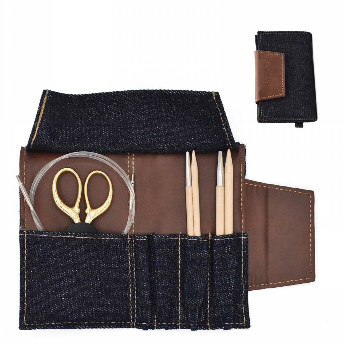 A small chocolate-colored Lykke Weekender travel needle case with a magnetic seal-to-close and a pocket for cords, tips, and buttons. It is made of denim and vegan leather with a camel-colored accent, and it is displayed open to show the interior compartments.