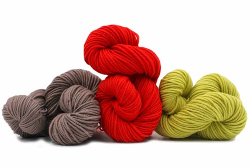 Three skeins of yarn in red, gray, and green on a white background