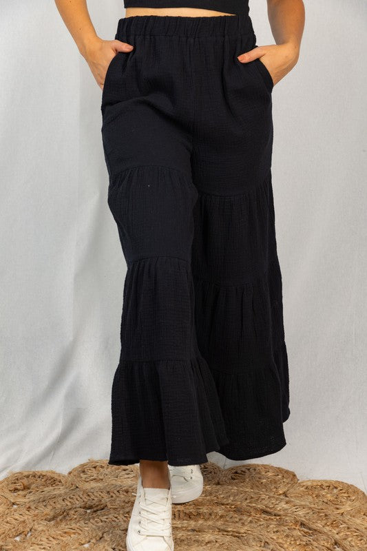 Pantalones negros con volantes y capas
