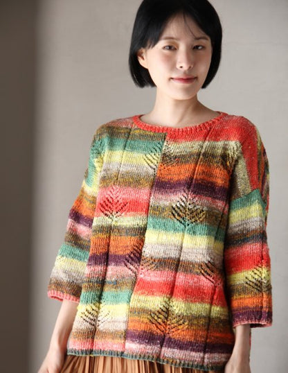 Woman wearing a colorful striped sweater against a plain background