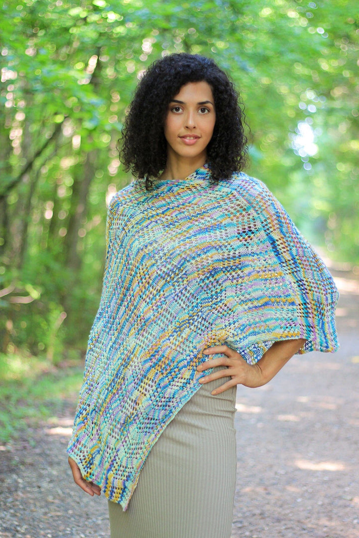 Woman wearing a colorful knitted poncho in a forest setting