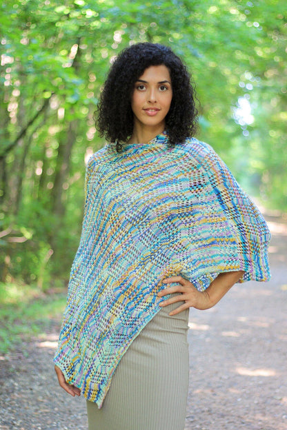 Woman wearing a colorful knitted poncho in a forest setting